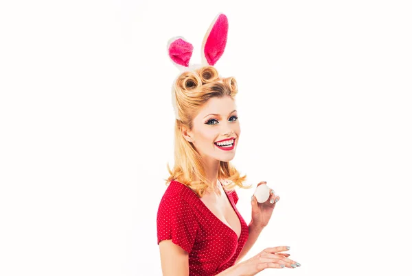 Щаслива жінка готується до Великодня. Красива блондинка з вухами кролика і пасхальним яйцем. Красива дівчина полює на великодні яйця. Прекрасна жінка в костюмі кролика. Рука з кольоровими великодніми яйцями . — стокове фото