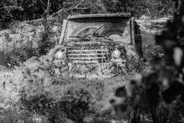 Off-road vehicle goes on the mountain. Mudding is off-roading through an area of wet mud or clay. Tracks on a muddy field. Track on mud. 4x4 Off-road suv car. Offroad car. Safari. — Stock Photo, Image