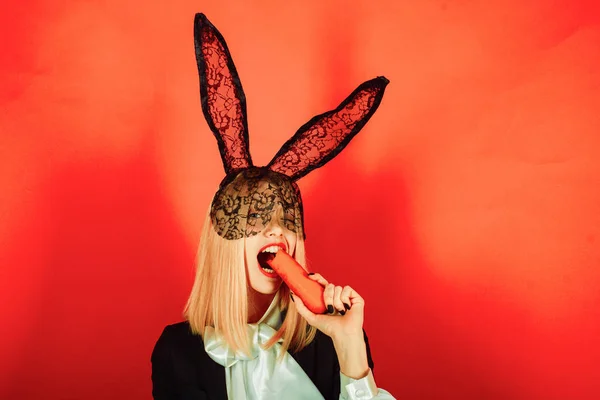 Ευτυχισμένη νεαρή γυναίκα που φοράει αυτιά κουνελιού και τρώει πασχαλινά αυγά. Χαρούμενο Πάσχα. — Φωτογραφία Αρχείου