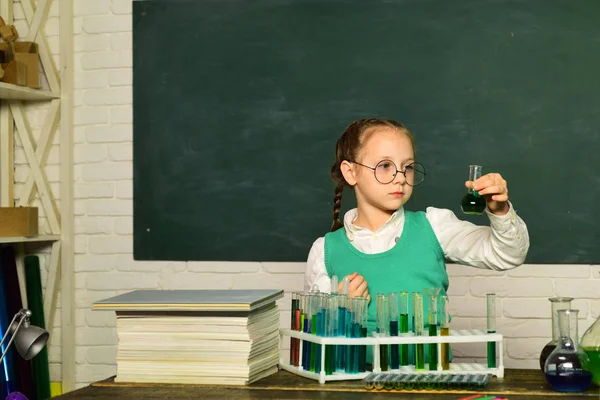 O que é ensinado em química. Ciência Química. Criança na sala de aula com quadro-negro no fundo. Criança do ensino fundamental . — Fotografia de Stock