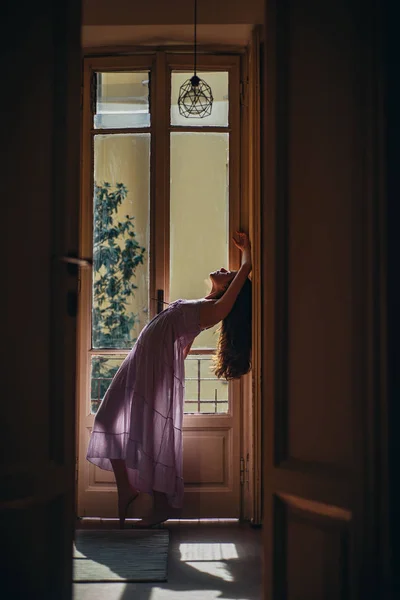 Menina bonita com cabelo comprido. Ela dança feliz. A rapariga está vestida de roupa de noite. Jovem mulher de pé perto da varanda. Modelo de moda em roupa interior sexy . — Fotografia de Stock