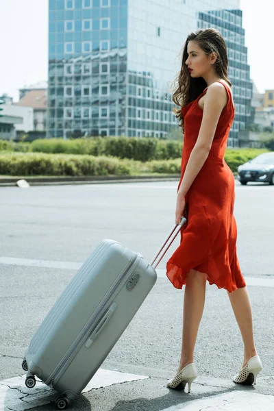 Woman traveler with suitcase. Sensual woman. Beauty and fashion. Sunny day. Fashion. Woman traveler with suitcase. Travel concept. Active lifestyle. Fashionable youth style.