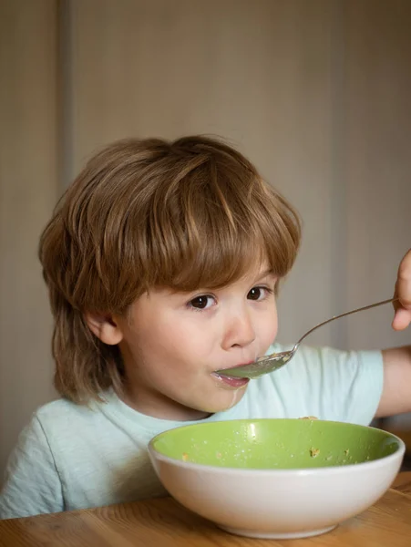 Dzieciak je. Mały chłopiec je śniadanie w kuchni. Jedzenie i picie dla dziecka. Chłopiec jedząc zdrowe jedzenie w domu. — Zdjęcie stockowe