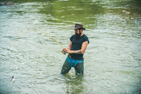 Människan fångar fisk. Hobby och rekreation. Livet är alltid bättre när jag fiskar. Fisher har långt spö. Sommarhelgen. Flugfiskens hobby för människan. Fiske efter storvilt. — Stockfoto