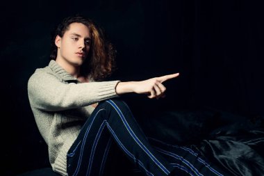 Ciddi yüzlü ve vahşi bir tarzı olan adam beyaz arka planda izole edilmiş. Giyim mağazası reklamı. Yakışıklı, güçlü, sportif, baştan çıkarıcı, kendine güvenen bir adam. Kentsel yaşam tarzı konsepti.