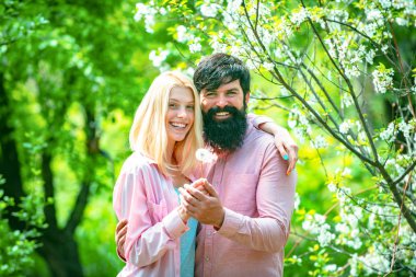 Bahar Parkı 'nda yürüyen ve güzel bahar çiçeklerinin tadını çıkaran çift. Mutlu Paskalyalar.