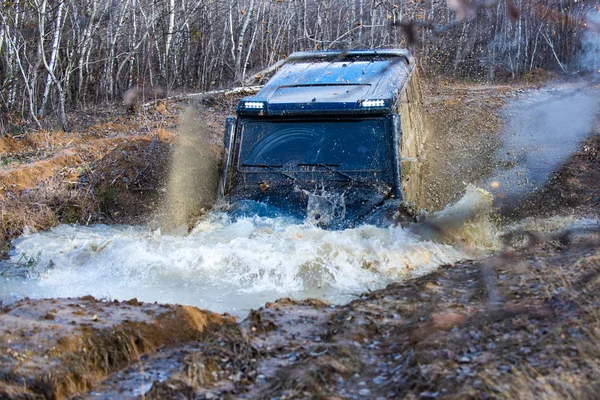 Jeep a szabadban kalandok. Mocskos autóvezetés nagy sebességgel. Letérni a kitaposott útról. A sár letér az útról nedves sárban vagy agyagban. terepjáró hegyi úton. — Stock Fotó