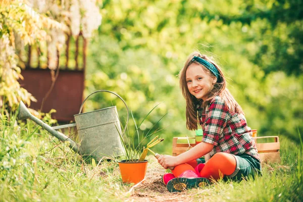 Μου αρέσει να περνάω χρόνο στη φάρμα. Ένας μικρός βοηθός στον κήπο. Χαρούμενος κηπουρός με ανοιξιάτικα λουλούδια. Ευτυχισμένη παιδική ηλικία. — Φωτογραφία Αρχείου