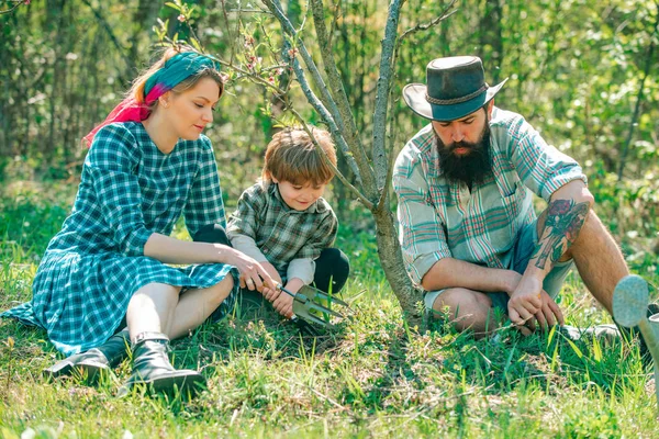 Lycklig familj på gården. Familjen går tillsammans genom vårens skördade fält. Maka och make med son plantering i grönsaksträdgården. — Stockfoto