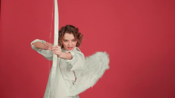 Valentines Day people concept. Angel girl with Bow and arrow over red background. Love Concept. Funny angel woman with Bow and arrows in his hands on red background. — Stock Video