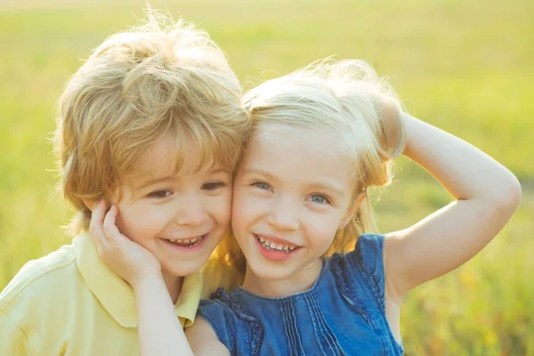 Kinder haben Spaß auf dem Feld vor dem Hintergrund der Natur. Sommerporträt glücklicher süßer Kinder. Niedliche kleine Kinder genießen auf dem Land. — Stockfoto