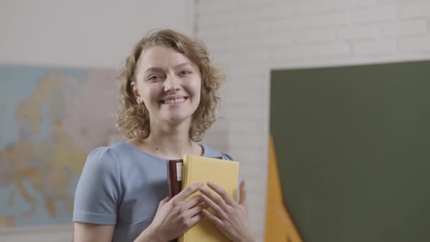 Schüler oder junger Lehrer mit Büchern im Klassenzimmer. Bildung. — Stockvideo