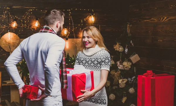 Wish you merry Christmas. Woman and man are giving Christmas gifts to each other. Lovely happy couple. Christmas couple in love. — Stock Photo, Image