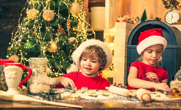 Tradições de Natal da família. Crianças a cozinhar para o Natal. Crianças engraçadas estão preparando pão de gengibre para o Natal. Cookies para Papai Noel . — Fotografia de Stock