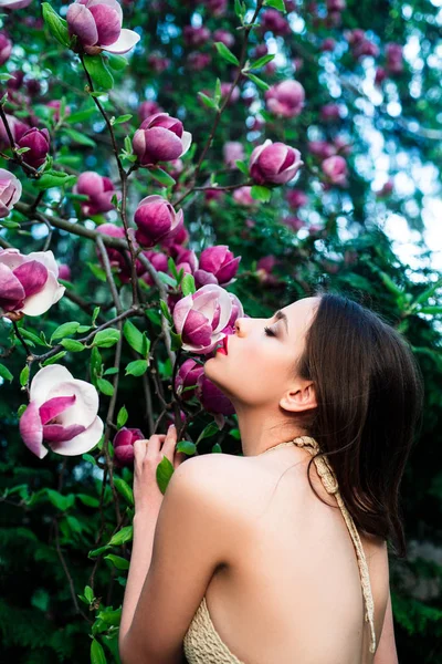 Concepto de moda de primavera. Moda chica primavera en primavera Magnolia flores fondo. Mujer en flor de primavera fondo . — Foto de Stock