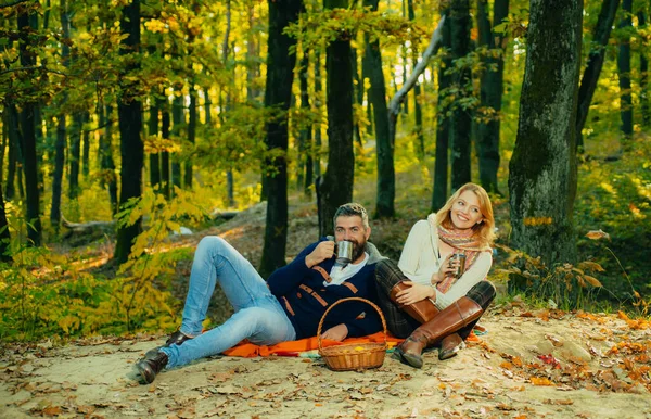 Aşık romantik çiftin güzel bir sonbahar parkında randevusu var. Kadın ve erkek sıcak kıyafetler giyip bir fincan sıcak çay içiyorlar. Genç bir aile çifti. Aile kavramı. — Stok fotoğraf