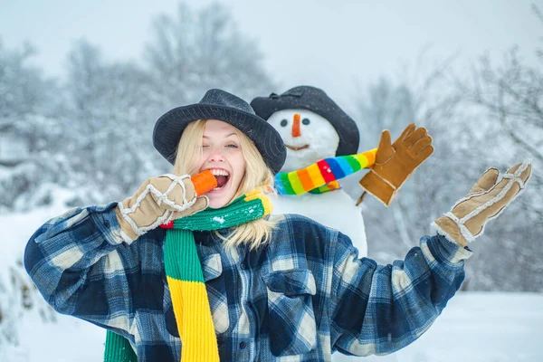 Bonhomme de neige avec drôle de nez de carotte avec fille amusante. Portrait de mode de jeune fille modèle à l'intérieur avec bonhomme de neige de Noël. Préparation de Noël - fille drôle faire bonhomme de neige . — Photo