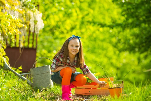 Agricoltore bambino nella fattoria con sfondo di campagna. Piccolo giardiniere felice con fiori di primavera. Agricoltore minorile che lavora in campo . — Foto Stock