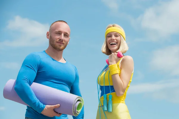 Les jeunes entraîneurs sportifs apprécient leur profession. Concept de vêtements de sport couleur. Tapis de yoga et corde à sauter, entraînement physique pour débutants . — Photo