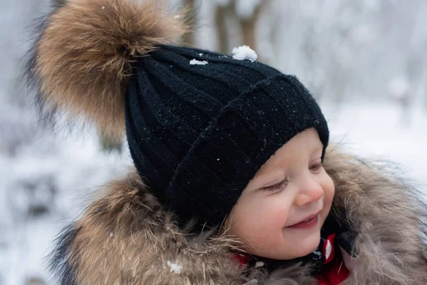 Kışın tatlı küçük bir çocuk. Parktaki küçük çocuk çok mutlu. Kış parkında oynayan neşeli çocuk. Mutlu çocuk karla eğleniyor. — Stok fotoğraf