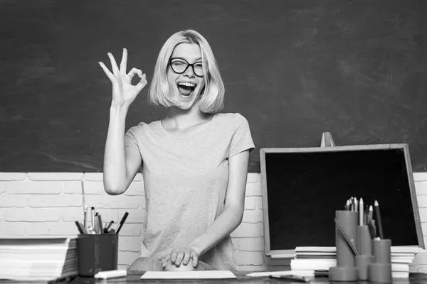 Portrait of funny young Caucasian female teacher wink and show OK. Young happy student. Portrait of Female University Student indoors. Beautiful teacher in classroom. — Stock Photo, Image