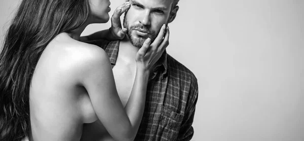 Σέξι καυτή γυμνή γυναίκα που αγγίζει το πρόσωπο ενός όμορφου γενειοφόρου άντρα απομονωμένου σε γκρι φόντο. Ερωτικά παθιασμένα ερωτικά προκαταρκτικά ζευγαριών. Φύλο επιθυμία και σχέση έννοια. — Φωτογραφία Αρχείου