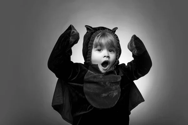 Niños felices en Halloween. Niños divertidos en trajes de carnaval sobre fondo naranja. Cara de miedo. Caras de horror. Cara graciosa. Los niños en América celebran halloween . — Foto de Stock