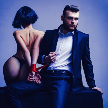 Takıl ve baştan çıkar. Seksi, çıplak kalçalar. Tutkulu aşıklar. Seks hakimiyeti. Seks teslimiyeti. Maço, bakımlı hippi ve çıplak seksi kadın ellerini kırmızı kurdele ile bağlamış. Cinsel ilişki. Seks oyunu