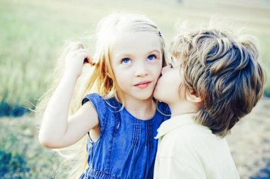 Çocuklar mavi gökyüzü arka planına karşı yeşil alanda eğleniyorlar. Kutlama Sanat Kutlama Kartı. Güzel çocuklar. Aşık küçük melekler. Aşk konsepti. - Valentine. Aşk hikayesi..