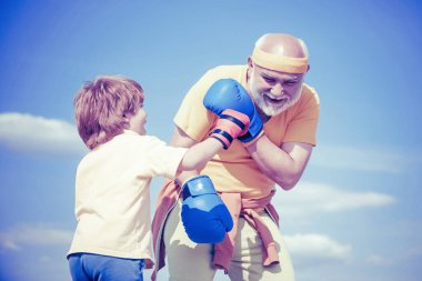 Boksu seviyorum. Komik şirin çocuk kavgası. Büyükbaba ve küçük çocuk boks eldivenleriyle egzersiz yapıyorlar..