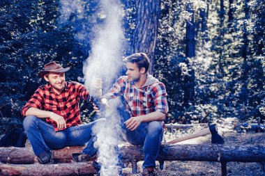 Friends spend leisure weekend forest nature background. Spring or autumn camping. Summer lifestyle. Resting after hard work. Two lumberjack men making picnic. Friends enjoy weekend camp in forest.
