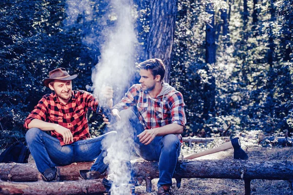 Friends spend leisure weekend forest nature background. Spring or autumn camping. Summer lifestyle. Resting after hard work. Two lumberjack men making picnic. Friends enjoy weekend camp in forest. — Stock Photo, Image