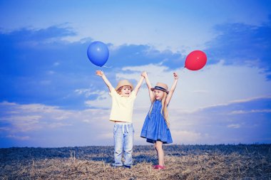 Yazın oynayan mutlu çocuklar. Küçük oğlan ve kız hayatın ve doğanın tadını çıkarıyorlar. Küçük kız ve oğlan yürümekten hoşlanırlar. Sahadaki mutlu kız ve oğlan. Pozitif küçük kız ve oğlan.