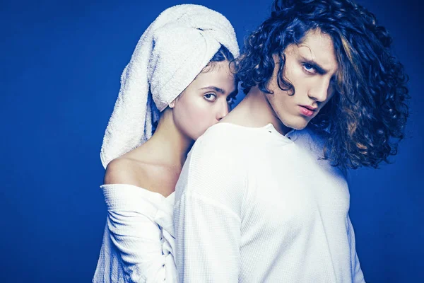 Hermosa pareja joven. Preciosa mujer con una toalla en la cabeza posando con un guapo moreno con cuerpo musculoso deportivo. Romántico y amor. Joven pareja feliz posando en el estudio. Sensualidad . — Foto de Stock