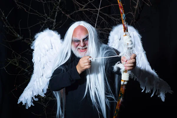 Art photo of a Angelic man. Senior man posing with angel wings. Evil vampire man. Man wizard with fantastic make up on demon face. Druid on black background. — Stock Photo, Image