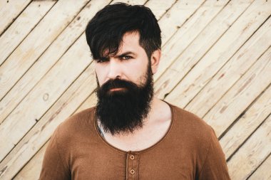 Guy with beard and modern hairstyle on street. Handsome male model - beard mustache and hairdo wears casual shirt.