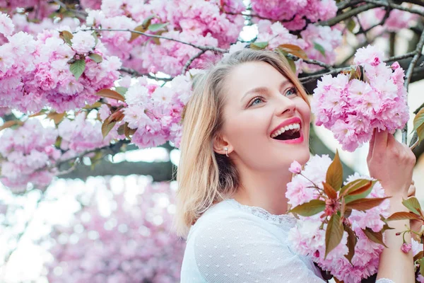 L'idea e il concetto di donne felici nella Giornata internazionale della donna. Donna felice con albero Sakura in fiore e giorno di sole . — Foto Stock