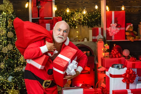 Suçlu Noel Baba bir çanta dolusu Noel hediyesiyle poz veriyor. Suçlu Noel 'i. Hediyeli komik kötü Noel Baba, hediyeli çanta. — Stok fotoğraf