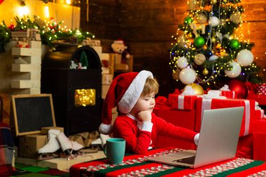 Little genius. Present box. Gift card concept. Happy christmas. Xmas tree. Family winter holidays and people concept. Christmas shopping concept. Little boy with laptop.