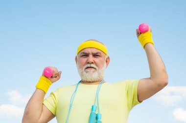 Dambılı kameraya bakan mutlu son sınıf öğrencisi. Yaşlılar için sağlık kulübü ya da rehabilitasyon merkezi. Spor merkezinde yaşlı sporcu dambılları kaldırıyor..