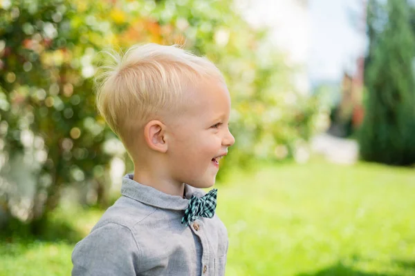 Entzückendes Kind, das Spaß hat. Kinderbetreuung. schöner Spaßtag für süße kleine Jungen in der Natur. Lustiges Kind in Anzug und Fliege. — Stockfoto