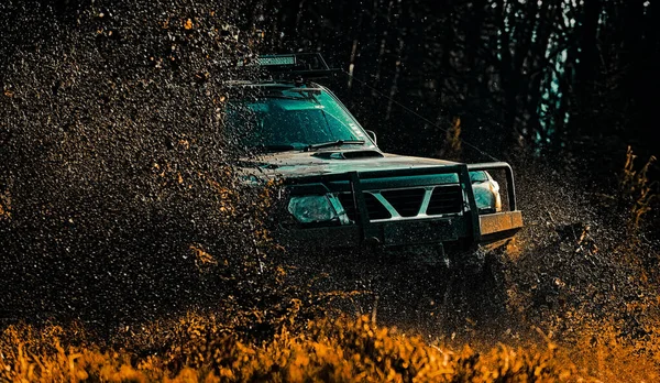 Mud and water splash in off-road racing. Drag racing car burns rubber. Extreme. Off-road car. Tracks on a muddy field. Offroad vehicle coming out of a mud hole hazard. Expedition offroader. — Stock Photo, Image