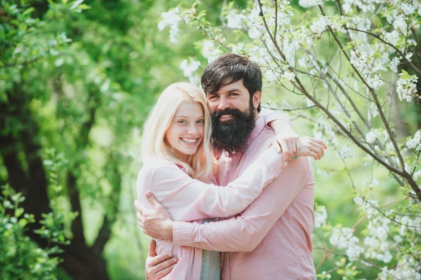 Зі святом Великодня концепція. Пара сміється і обіймається. Усміхнена пара закохалася в квітучий фон саду дерева . — стокове фото