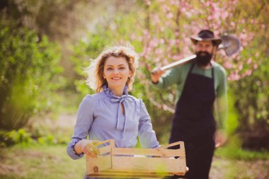 Country life. Portrait of wife and husband while working in garden. Bio food production concept. Spring gardening routine.