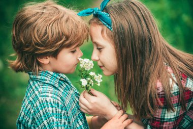 Yaz neşesi - tatlı kız ve oğlan karahindiba üflüyor. Sevgililer Günü teması.