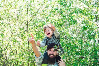 Happy family: father and children son on spring blossom garden background. Fathers day.