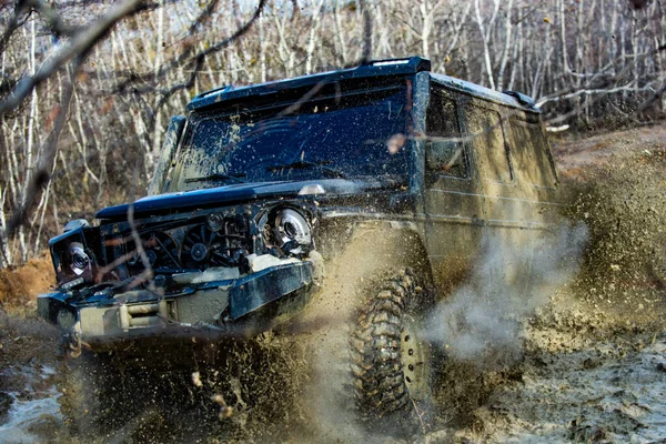 Water splash in off-road racing. Off-road vehicle goes on the mountain. Wheel in the mud. Off road car on mountain road. Extreme. — Stock Photo, Image