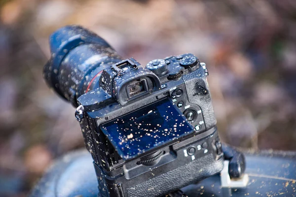 A dirty photo camera lens isolated on nature. Macro. Dustproof moisture protection. Close up dust and dirt on a camera lens. Macro view. Interchangeable lens camera with a sleek design. — Stock Photo, Image