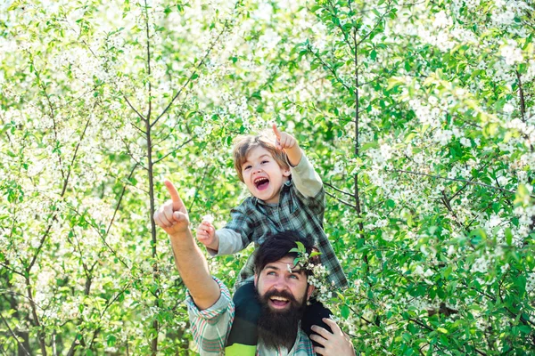 Famiglia felice: padre e figli figlio su sfondo giardino fiorito primaverile. Giorno di padri . — Foto Stock