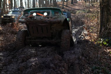 Four by four off road car crossing the mud. Travel and racing concept for four wheel drive off road vehicle. Fragment of offroad car stuck in dirt close up.